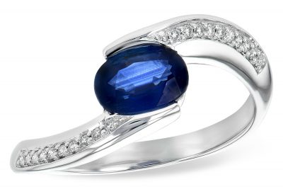 Oval .90ct sapphire set at an angle with split shank of 14k white gold with round accenting G SI1/SI2 diamonds set down the band totaling .08ct